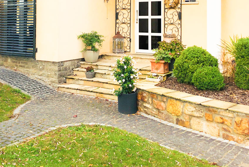 Gartenanlage von Jung Ökostein mit Naturstein-Pflaster und Natursteinmauer